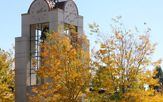The GBC clock tower set amongst trees full of autumn leaves.