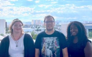 fostering-success-peer-educator-outing-1 A trio poses on balcony on a bright sunny day. The Las Vegas skyline can be seen in the distance