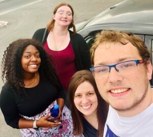 fostering-success-peer-educator-project-1 A selfie featuring four smiling people in a parking lot