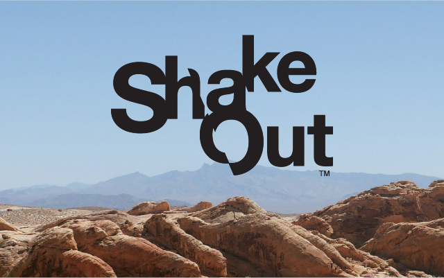 The 'Shake Out' logo superimposed over a blue sky with red rock cliffs below.