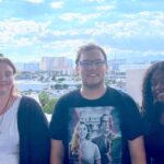 Three foster youth peer educators pose together. The Las Vegas strip can be seen in the background.