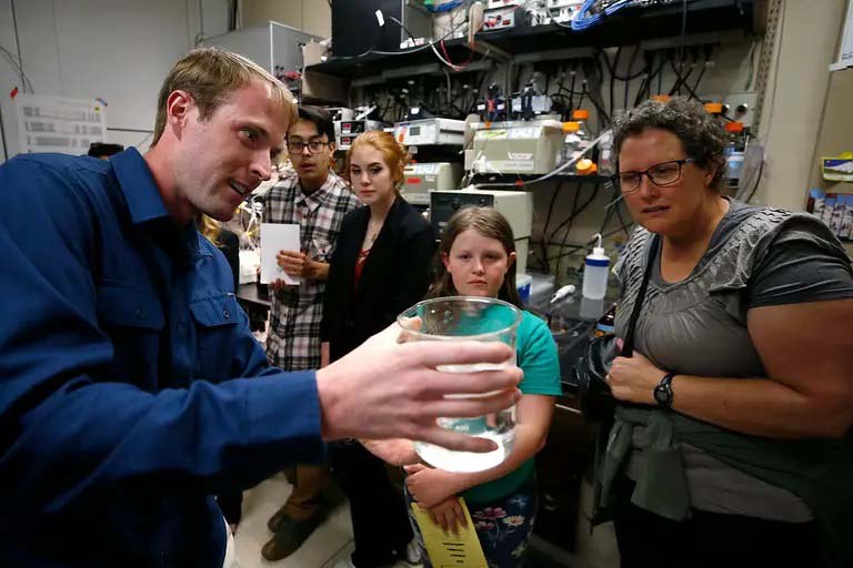 A DRI scientist conducts a chemistry dem for interested onlookers