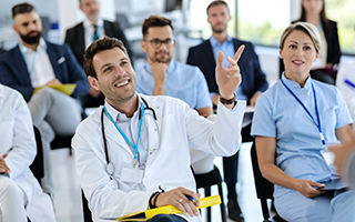 Row of seated medical students actively engaged in an informative discussion.