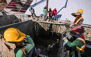 Workers in working gear spread out across a work site.